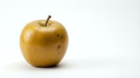 Golden apple with stem isolated on white background, suitable for food packaging, nutrition labels, healthy eating campaigns, and culinary design projects.