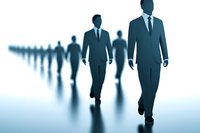 Business professionals walking in line formation on reflective surface, creating dramatic silhouettes against blue gradient background. Concept of leadership and teamwork.