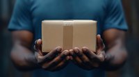 Person holding cardboard package box in cupped hands for delivery service, shipping and logistics business concept.