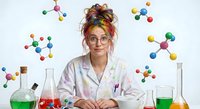 Young female scientist with colorful hair and glasses working in chemistry laboratory surrounded by molecular models and beakers with colored liquids.