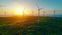 Wind turbines on green field at sunset, renewable energy farm generating sustainable electricity for environmental conservation and clean power production.