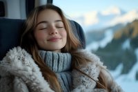 Young Caucasian woman with closed eyes and gentle smile wearing cozy knit turtleneck and fur coat relaxing against winter mountain landscape background.