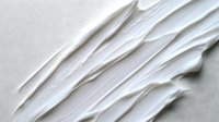 White cream texture smear on clean background. Smooth cosmetic product application stroke for skincare and beauty industry marketing materials.