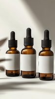 Amber glass dropper bottles with blank white labels casting soft shadows on light background. Essential oil or serum packaging mockup for cosmetic branding.