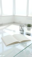 Open book on glass table with white lantern and succulent plant in bright minimalist interior space for reading and relaxation.