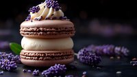 Chocolate and vanilla macarons stacked with buttercream filling, topped with lavender sprinkles and surrounded by fresh lavender flowers on dark background.
