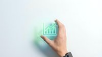 Hand holding a glowing green growth chart icon, symbolizing financial success, business analytics, and investment progress on a light background.