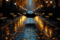 Person with umbrella walking on wet autumn alley at night. Golden street lights reflect on rainy pavement covered with fallen leaves creating atmospheric mood.