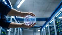 Hands holding glowing digital sphere with network connections in modern server room with blue lighting and data center equipment background.
