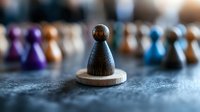 Dark wooden chess pawn piece standing alone on circular base with blurred colorful game pieces in background. Strategic thinking and leadership concept.