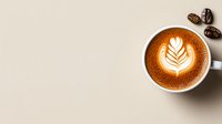 Hot cappuccino with artistic leaf latte art pattern in white ceramic cup on beige background with roasted coffee beans, minimalist coffee shop composition.