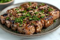 Grilled beef steak slices with sesame seeds and fresh herbs on dark plate. Perfect for restaurant menus, cooking blogs, and culinary presentations.