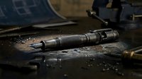 Diesel fuel injector lies on dark workbench with metal shavings and tools, automotive repair and engine maintenance concept for industrial mechanics.
