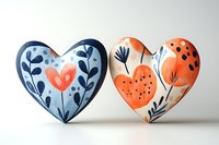 Two decorative ceramic hearts with floral folk art patterns in blue and orange, handcrafted for home decor or Valentine's Day gifts.