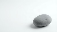 Smooth gray pebble stone isolated on white background for zen meditation spa wellness design projects and natural decoration concepts.
