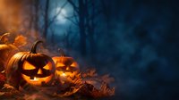 Glowing jack-o-lantern pumpkins with carved faces sitting among autumn leaves in spooky forest setting with moonlight and bare trees for Halloween.