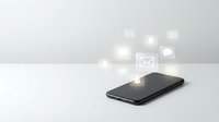 Modern smartphone with glowing social media and communication icons floating above screen on clean white surface for digital marketing concepts.