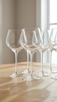 Empty wine glasses arranged on wooden table in bright modern kitchen interior for entertaining and dining occasions.