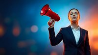 Professional businesswoman holding red megaphone against colorful bokeh background for corporate communication and leadership marketing campaigns.