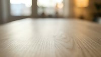 Wooden table surface with blurred interior background, suitable for product placement, mockups, and commercial design projects.