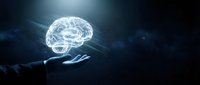 Glowing transparent brain hologram floating above businessman hand against dark blue background. Artificial intelligence and neuroscience concept.