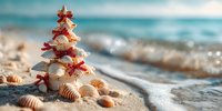 Christmas tree made of seashells and starfish on sandy beach with ocean waves, perfect for tropical holiday themes.