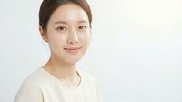 Young Asian woman with natural makeup and gentle smile on white background, copy space for skincare, beauty, and wellness concepts.