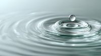 Water drop impact creating concentric ripples on calm surface with suspended droplet above circular waves.