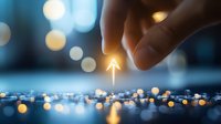 Glowing arrow pointing upward held by fingers against blurred blue and gold bokeh background, symbolizing growth, success and future direction in business.