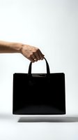 Male hand holding elegant black leather handbag on white background isolated for fashion and accessory design projects.