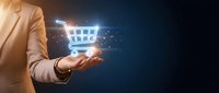 Professional businessman holding glowing digital shopping cart icon with network connections for e-commerce and online retail technology concepts.