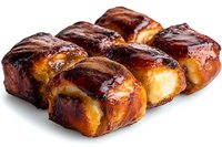 Freshly baked sweet rolls with caramelized sugar glaze and chocolate drizzle on white background, appetizing pastries photographed in natural light.