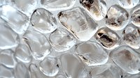 Clear ice cubes with crystalline structure in macro photography showing transparency, reflections and natural patterns. Fresh frozen water with melting drops.