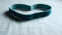 Teal silicone wristband bracelet on textured fabric surface for awareness campaigns and promotional events.