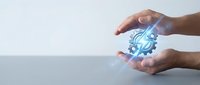 Hands protecting glowing blue gear mechanism symbolizing business protection, technology security and industrial innovation concepts.