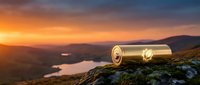 Golden binoculars on rocky mountain peak overlooking scenic valley landscape at sunset, perfect for travel and adventure concepts.