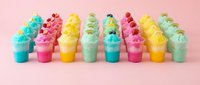 Colorful fluffy slime containers in pink, yellow, turquoise and green arranged in a row on pink background. Isolated design element for children's product packaging, craft tutorials, toy marketing and educational content.