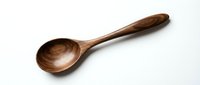 Handcrafted wooden spoon with natural grain pattern isolated on white background for kitchen utensils and cooking designs.