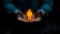 Glowing orange human figure silhouette floating above cupped hands against dark background, representing life protection, spirituality and human care concept.