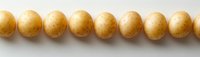 Fresh yellow baby potatoes arranged in straight line on white background, raw organic produce for cooking and food preparation, isolated overhead view.