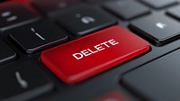 Red delete key on black computer keyboard, close-up view for technology, data removal, cybersecurity, and digital management concepts.