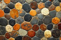 Natural stone mosaic pattern with colorful round pebbles in earth tones creating decorative wall or floor surface for interior design projects.