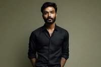 South Asian man with beard wearing black button-up shirt against olive green background, conveying confidence and professionalism for business portraits.