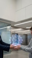 Business professionals shaking hands with digital network hologram in modern office representing partnership and technological collaboration.