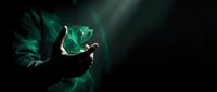 Hands holding glowing green crystal cube with mystical energy rays and magical light effects on dark background for fantasy gaming and supernatural concepts.