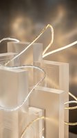 Elegant golden and silver ribbons flowing around transparent gift bags with warm bokeh lighting creating luxurious shopping atmosphere.