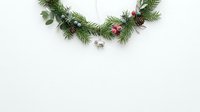 Festive evergreen garland with pine cones and pink ornaments arranged on white background, ready for holiday greeting cards, seasonal marketing materials and festive design projects.