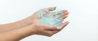 Hands holding glowing digital hologram with technology icons and data visualization on white background for innovation and future concepts.