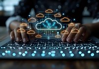 Glowing cloud computing network with connected orange and blue neon icons floating above laptop keyboard, hands typing in dark environment with bokeh lights.