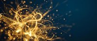 Golden light trails and sparkling particles create dynamic energy burst with flowing curves and bright glowing effects on dark blue background for motion graphics.